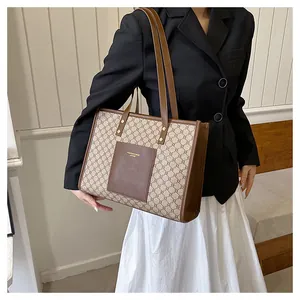 Macro detail of vintage monogram tote bag with brown leather pocket and gold lettering