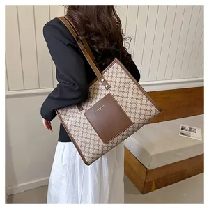 Detail of vintage monogram tote bag with brown leather trim and gold fashion lettering