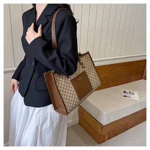 Macro detail of monogram canvas tote bag with brown leather trim and handle