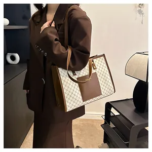 Close-up of geometric pattern canvas tote with brown leather trim and fashion bags logo