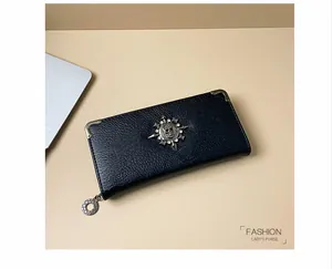 Dettaglio portafoglio in pelle nera stile punk con teschio di strass e angoli in metallo