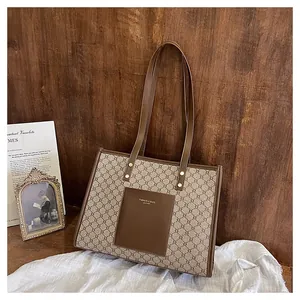 Detailed view of brown vintage monogram tote bag with leather pocket and long shoulder straps
