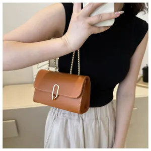Détail du sac bandoulière en cuir caramel avec boucle en U dorée et coutures blanches