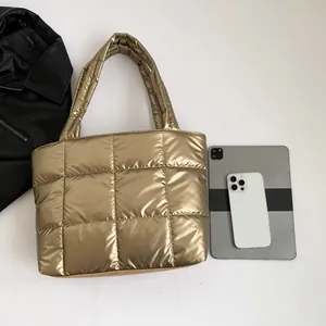 Metallic gold quilted tote bag with large capacity shown with phone and tablet