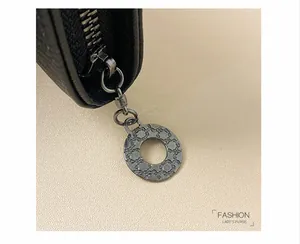 Dettaglio macro del portafoglio in pelle Saffiano nera con tiralampo tondo in metallo teschio