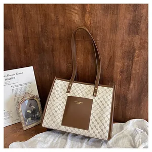Detailed macro view of vintage brown tote bag with geometric patterns and leather front pocket