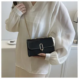 Detail of black crossbody bag with premium leather texture and oval golden metal lock