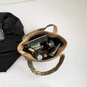 Spacious quilted tote bag in metallic bronze finish showing large interior capacity