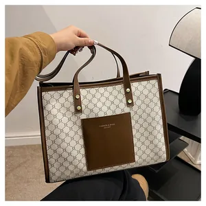 Detail of large tote bag with brown vintage geometric pattern and leather front pocket