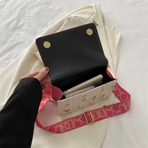 Chic floral embroidered acrylic handbag with pink wide strap and elegant metal hardware