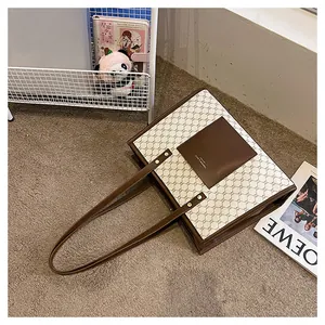 Close-up of a large tote bag featuring vintage pattern canvas and brown leather pocket