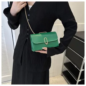 Détail du petit sac vert avec boucle en U dorée et bandoulière en chaîne chic