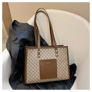 Detail of vintage pattern tote bag with leather trim and gold branded pocket