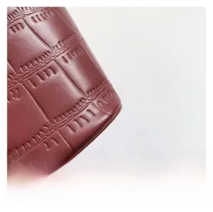 Close-up of burgundy crocodile pattern leather texture showing embossed details