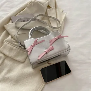 Sac à main argenté brillant avec nœuds roses et bandoulière amovible style balletcore