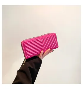 Detail of rose pink chevron quilted long wallet with golden zipper and glossy finish