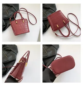 Detailed views of burgundy croc-embossed bucket bag with gold hardware and strap