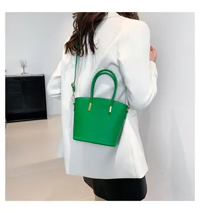 Chic green crocodile pattern handbag shown on model for stylish everyday commute