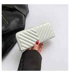 Macro shot of white glossy faux leather wallet featuring a stylish V-quilted pattern
