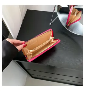Detail of pink long wallet showing card slots and beige interior compartments