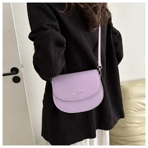 Détail d'un sac selle lavande avec impression FASHION TREND et boucles en métal argenté