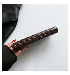 Detailed side view of brown patent leather wallet with elegant V-shaped quilting texture