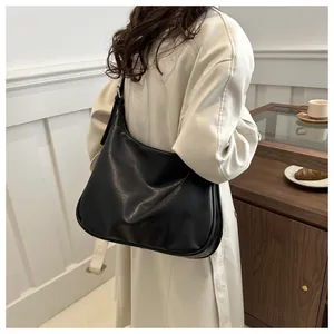 Detail der schwarzen minimalistischen Tasche aus PU-Leder in Halbmondform und Seitenprofil