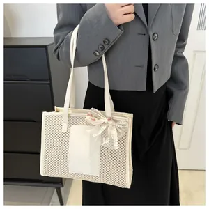 Detail of cream woven tote bag featuring a floral lace bow and textured mesh surface