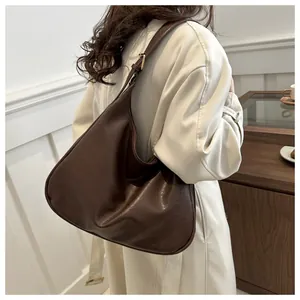 Detail der dunkelbraunen Hobo-Tasche mit breitem Schultergurt und Metallschnalle