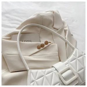Dettaglio della trama trapuntata bianca su una piccola borsa a tracolla quadrata chic