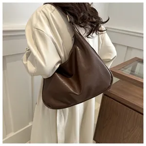 Detail der großen dunkelbraunen Vintage-Tote-Tasche aus Kunstleder an einem Modell