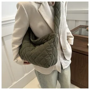 Détail du sac à bandoulière en velours côtelé vert foncé avec surpiqûres en losange