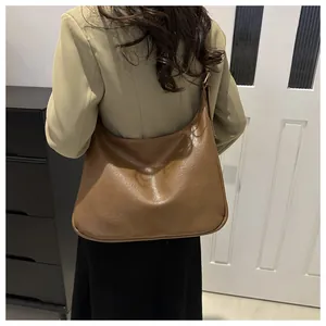 Detail der karamellbraunen Hobo-Tasche mit Vintage-Lederstruktur und breitem Gurt