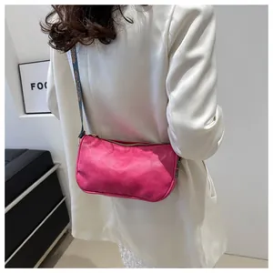 Detail of a bright rose pink crossbody bag featuring a woven jacquard shoulder strap