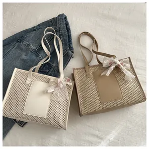 Detail of straw woven tote bags in beige and khaki with lace flower bow accents
