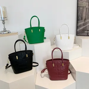 Chic stone pattern bucket bags in four colors on white display stands with metal hardware
