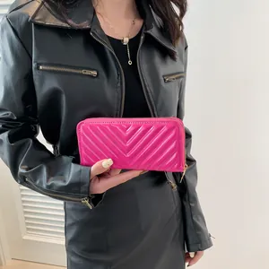 Magenta glossy patent leather long wallet with V-pattern quilting and gold zipper closure