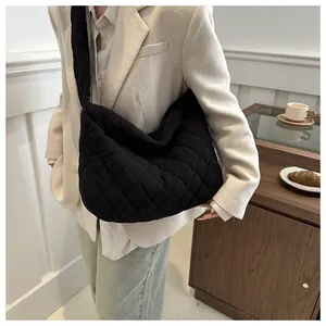 Sac hobo noir en velours côtelé matelassé porté par un mannequin en intérieur