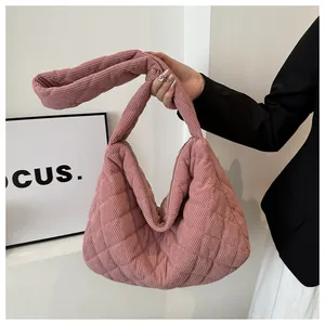 Détail du sac à main en velours côtelé rose avec texture matelassée et fermeture éclair