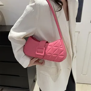 Borsa quadrata trapuntata rosa con tracolla lunga e fibbia decorativa su una modella