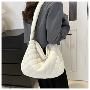Gros plan sur la texture en velours côtelé matelassé ivoire et les coutures du sac hobo