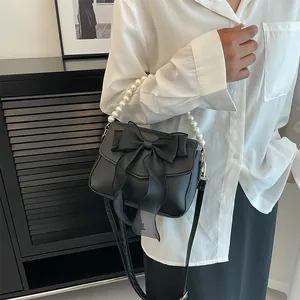 French lace pearl bow bag shown on model as elegant crossbody and handbag style