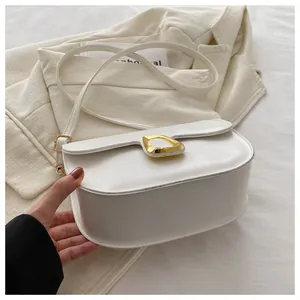 Detail of white saddle bag showing smooth leather texture and golden ring buckle