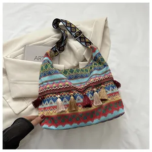 Detalle del bolso tote bohemio tejido con patrones geométricos y borlas decorativas