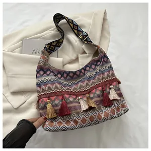 Detalle del bolso tote bohemio tejido con flecos y correa ancha bordada de estilo étnico