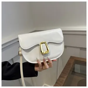 Close-up of a white semi-circle saddle bag with glossy PU leather and golden buckle