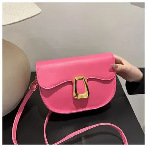 Detail of pink saddle bag with golden trapezoid metal buckle and smooth leather texture