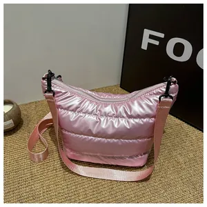 Dettaglio della borsa imbottita rosa con trama lucida e tracolla regolabile