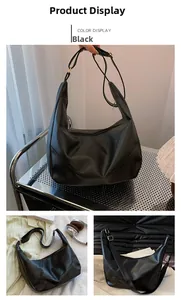 Detail of black large capacity hobo bag with leather texture and golden hardware accents