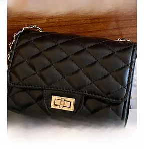 Close-up of golden rectangular metal lock on black quilted leather chain bag